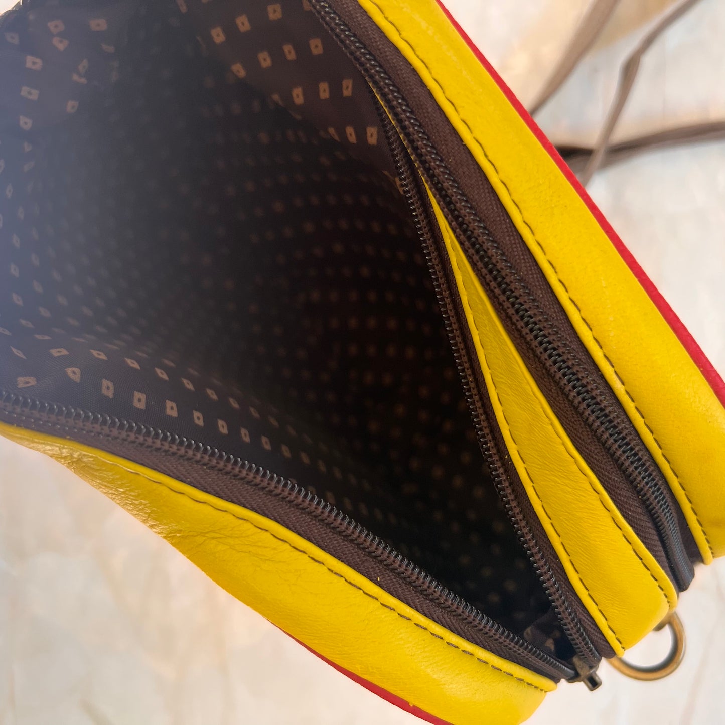 top view of Bristol crossbody with one zipper unzipped showing interior.