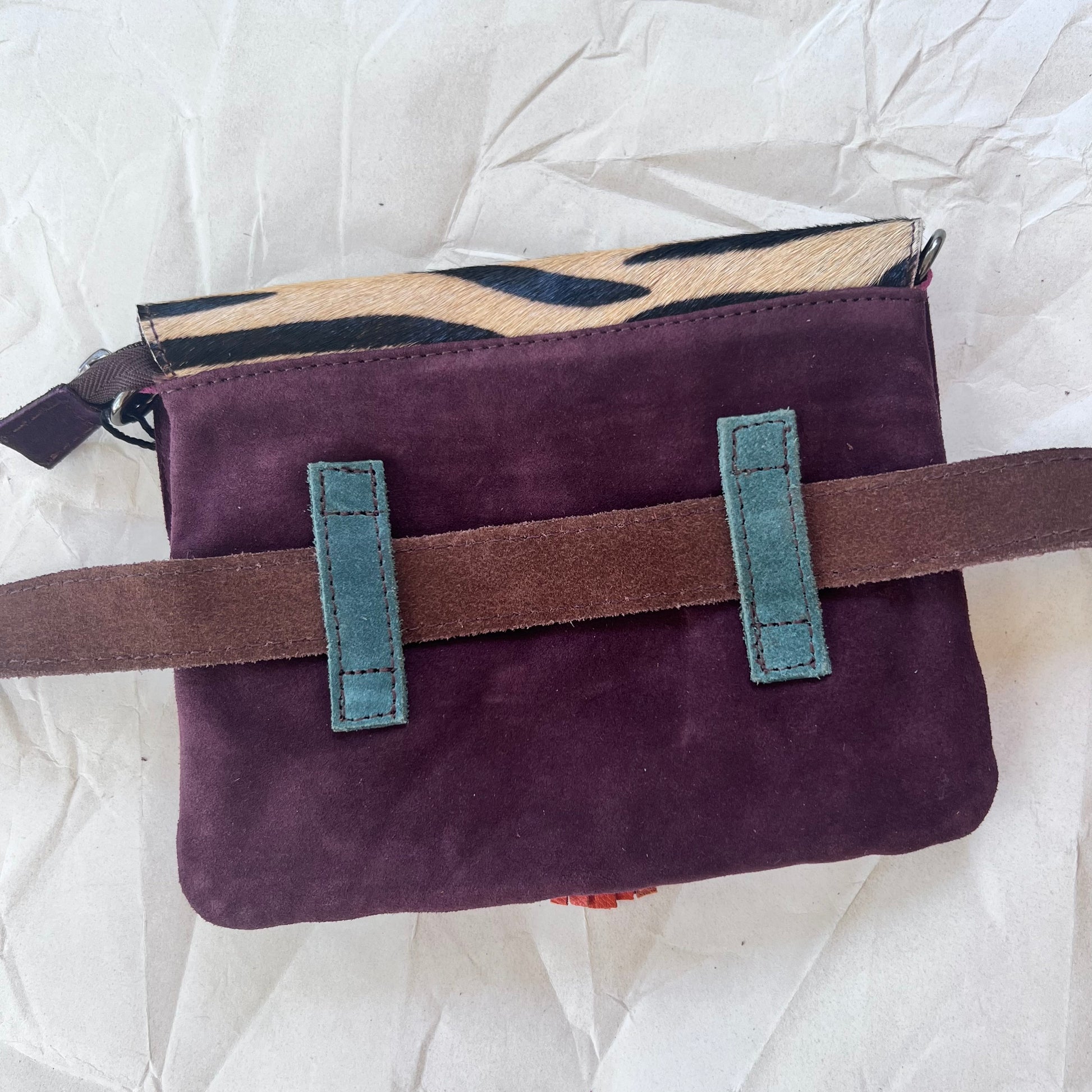 solid purple back of bag with loops holding belt.