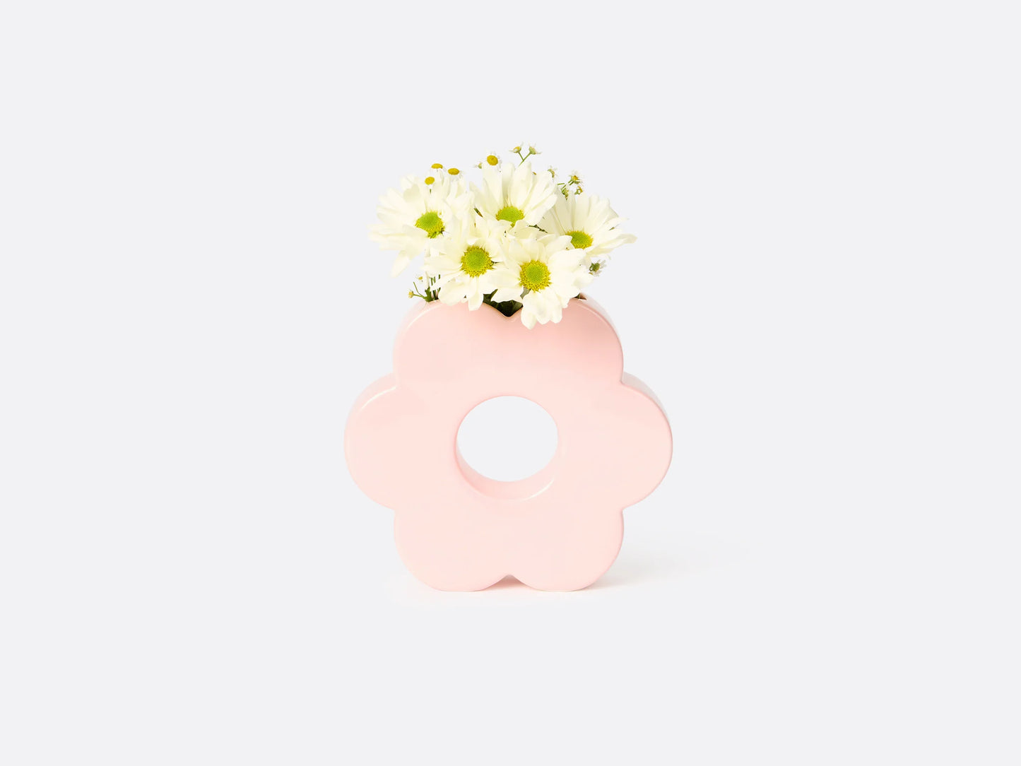 pink flower shaped vase with daisies in it.