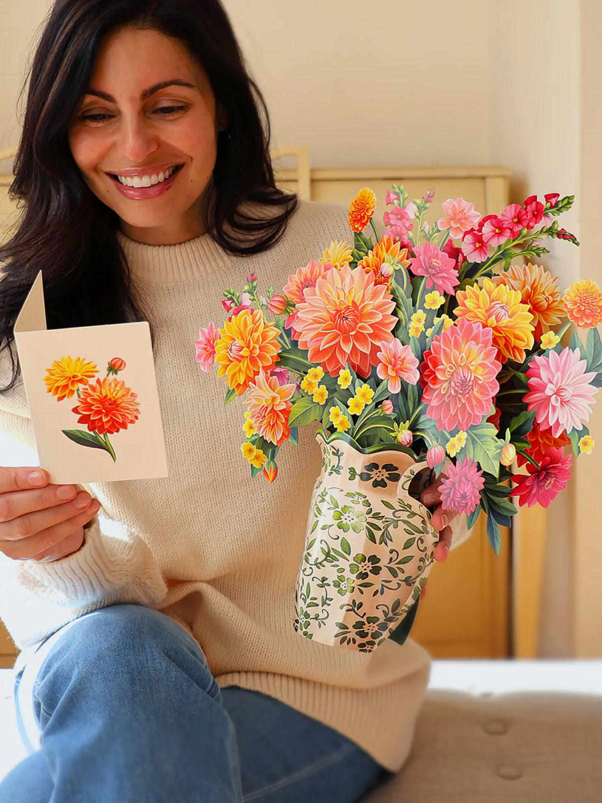 a person reading a note card and holding the Dahlia Sunrise Pop-Up Bouquet