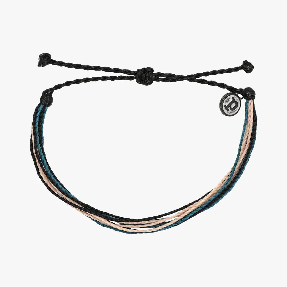 Pura Vida multi strand corded bracelet in varying shades of blue, black and tan with a Pura Vida logo charm