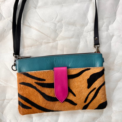 turquoise rectangular bag with animal print pocket, black shoulder strap.