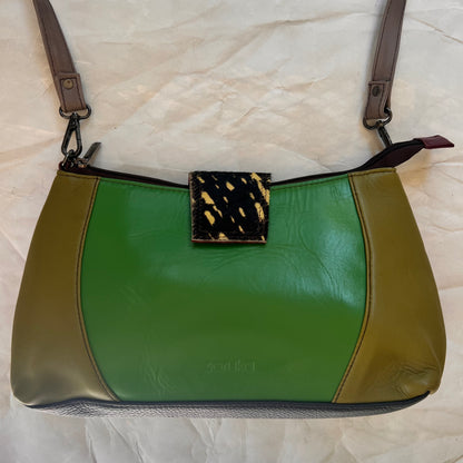 front on Amanda bag with color blocks of green and an animal print tab over top zipper.