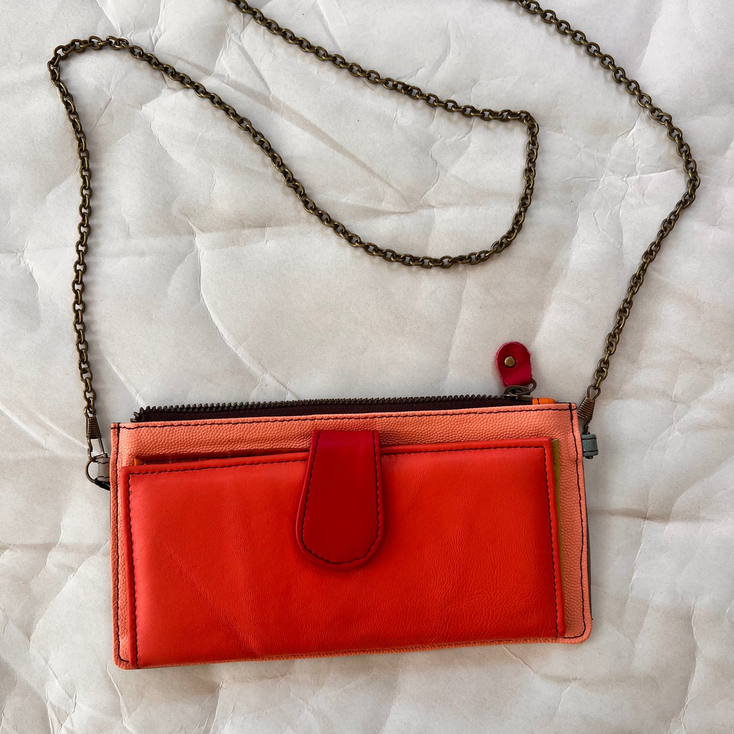 coral kimber wallet with crossbody chain attached.