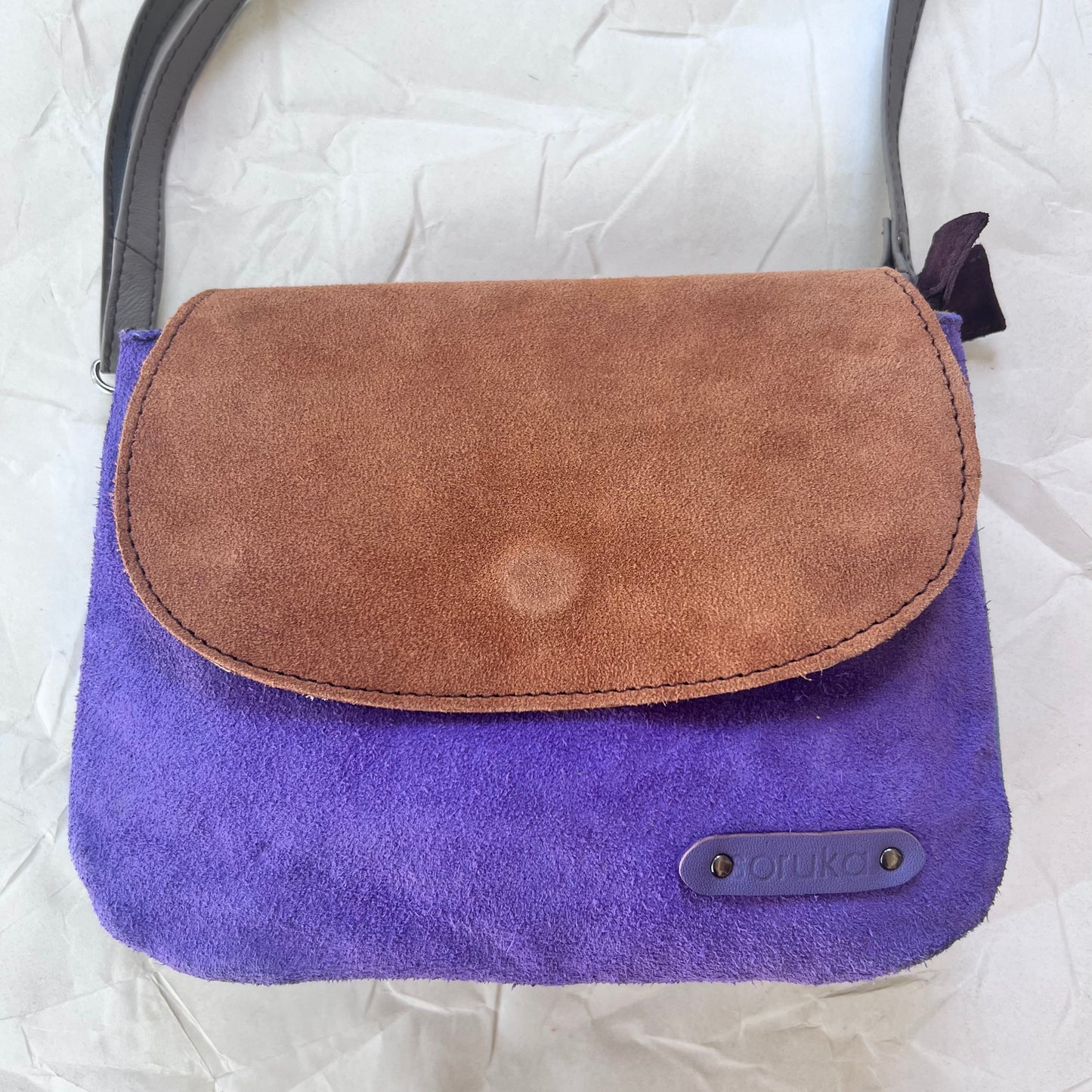 other side of leo purse with purple body and brown flap.