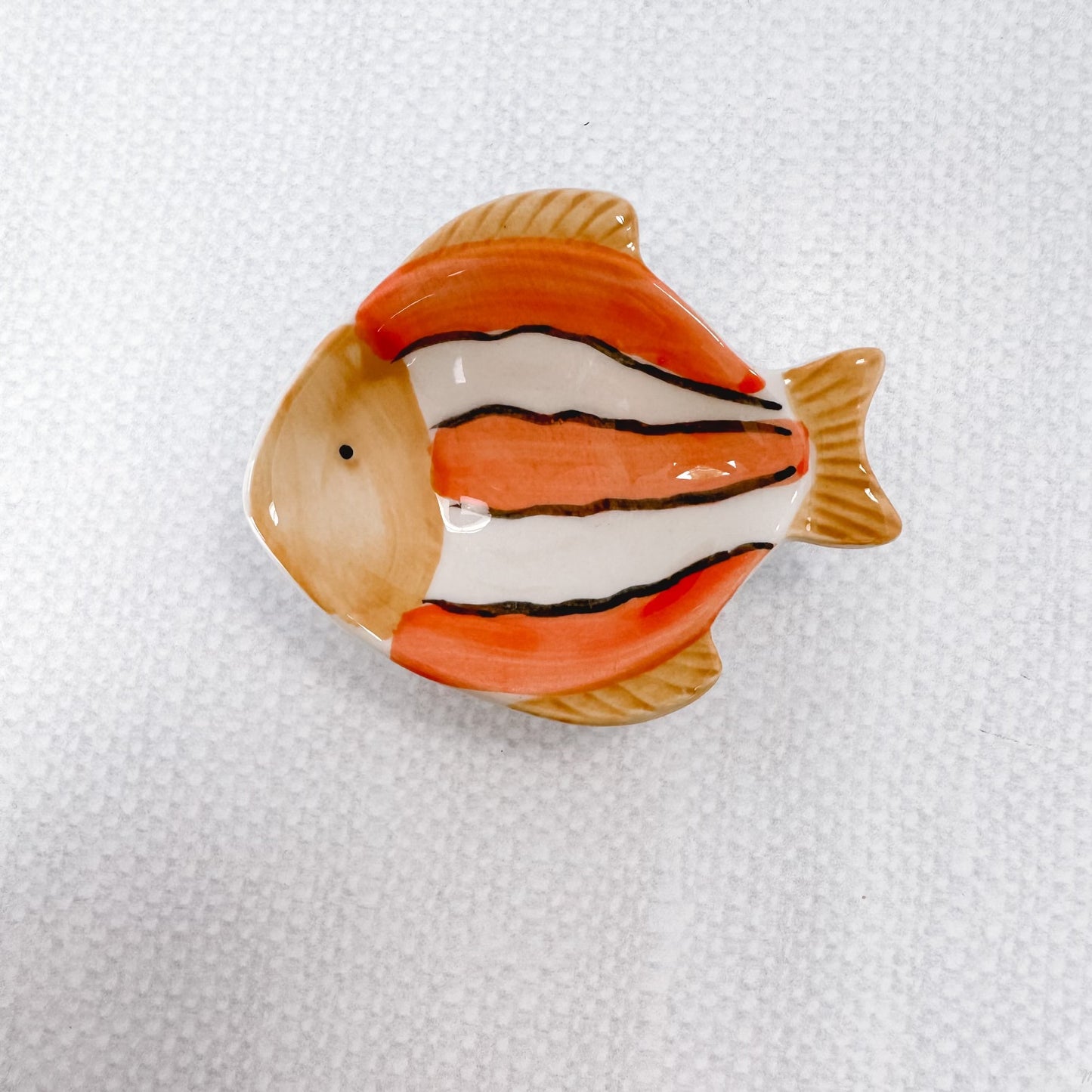 orange and white striped fish with light brown fins.