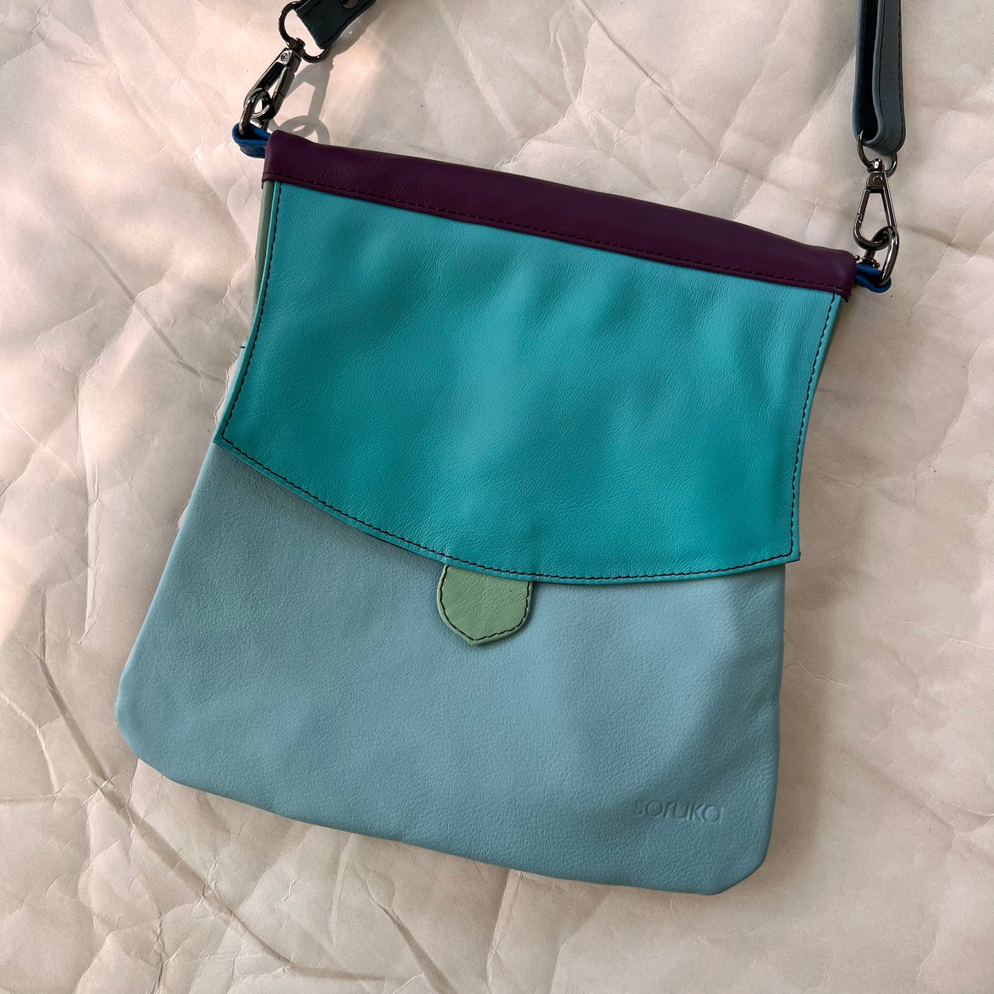 greta bag with bright blue flap over light blue body.