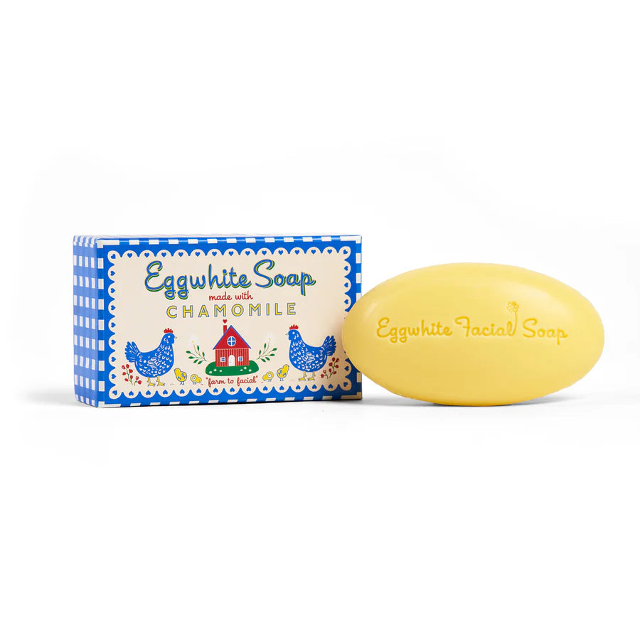 Yellow oval bar of soap set next to its blue gingham box packaging.