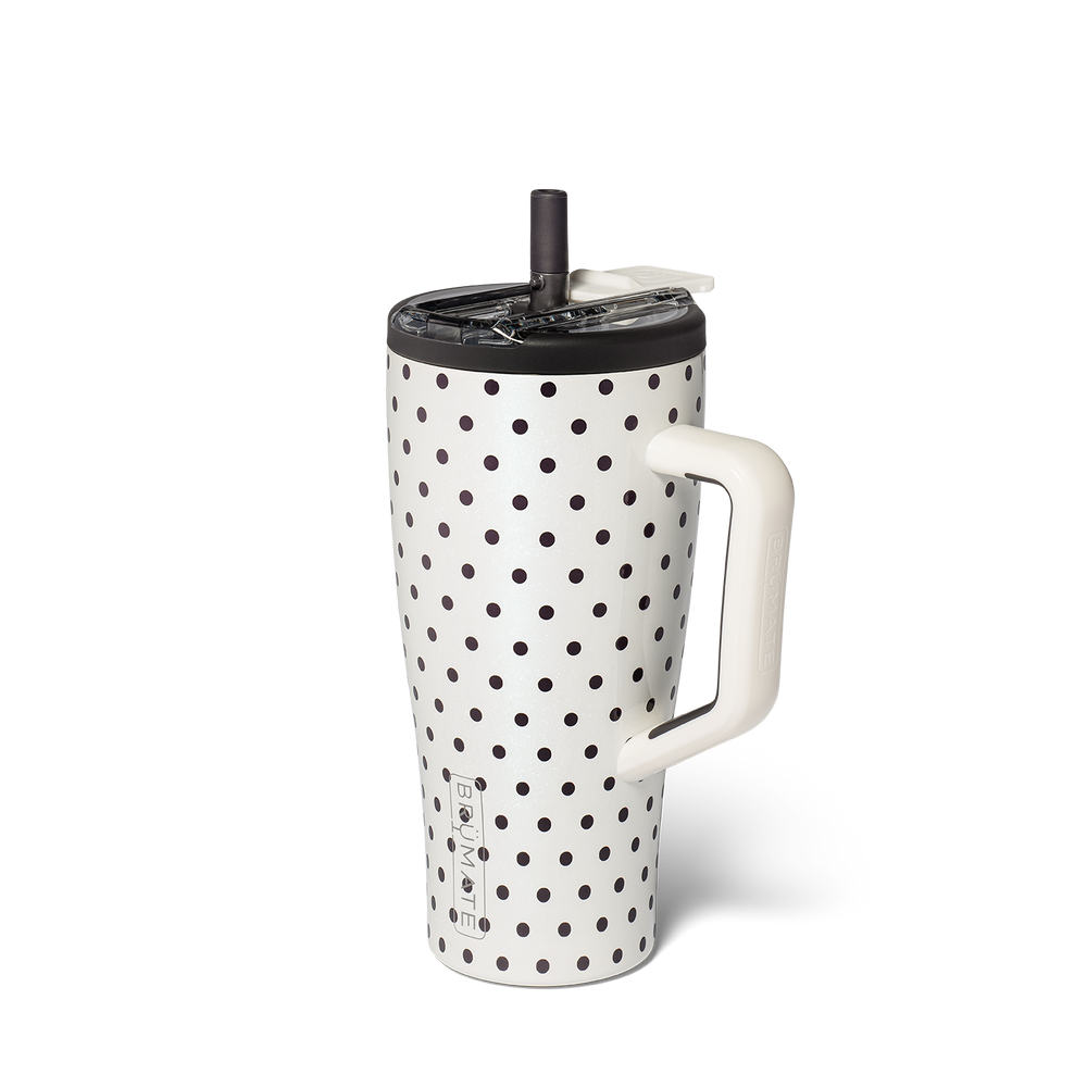 A white insulated travel tumbler with black polka dots, featuring a white handle, a black lid, and a clear plastic lid with a black straw, shown on a white background.