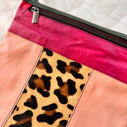 close-up of peach greta bag with animal print block in the center with pink stripe and zipper across the top.