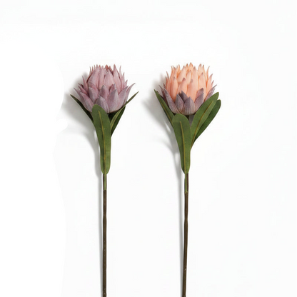 Two artificial protea flowers with green stems on a white background