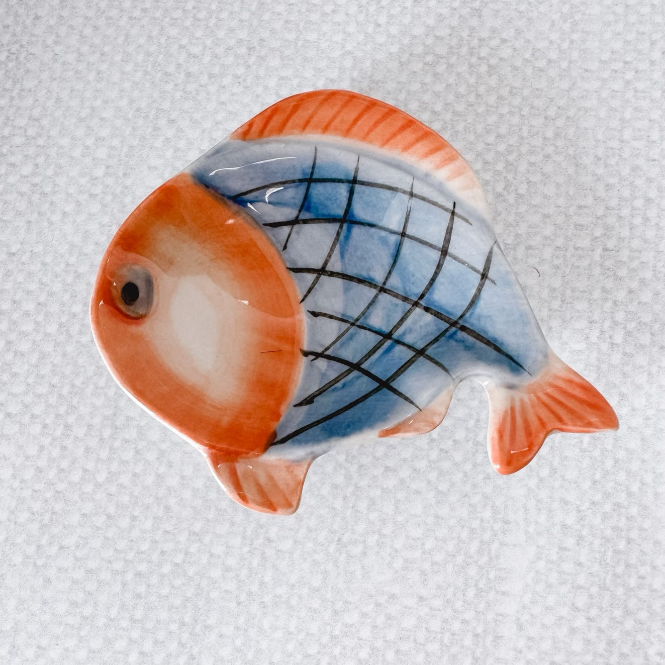 blue fish with black lines and orange fins.
