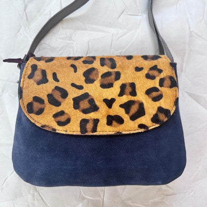 leo purse with navy body and cheetah print flap.