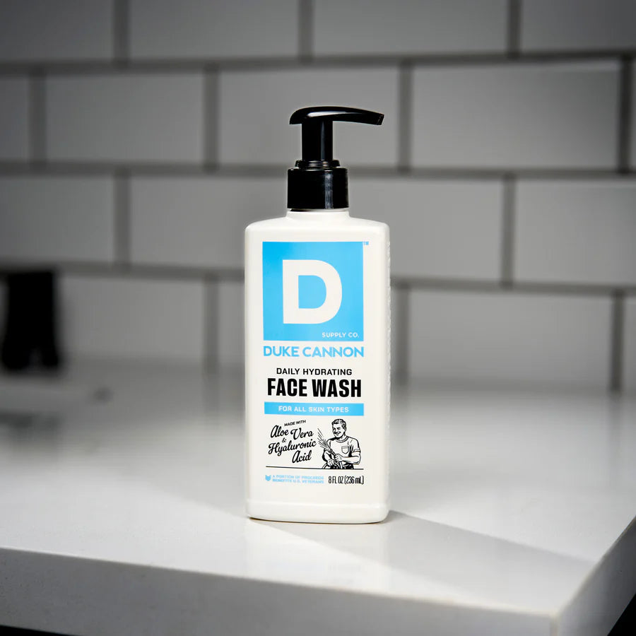 Duke Cannon face wash bottle on a bathroom counter with tiled wall background