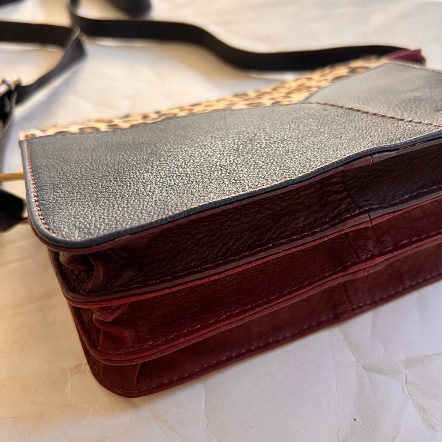 bottom view of meredith purse showing 3 burgundy and maroon gussets.