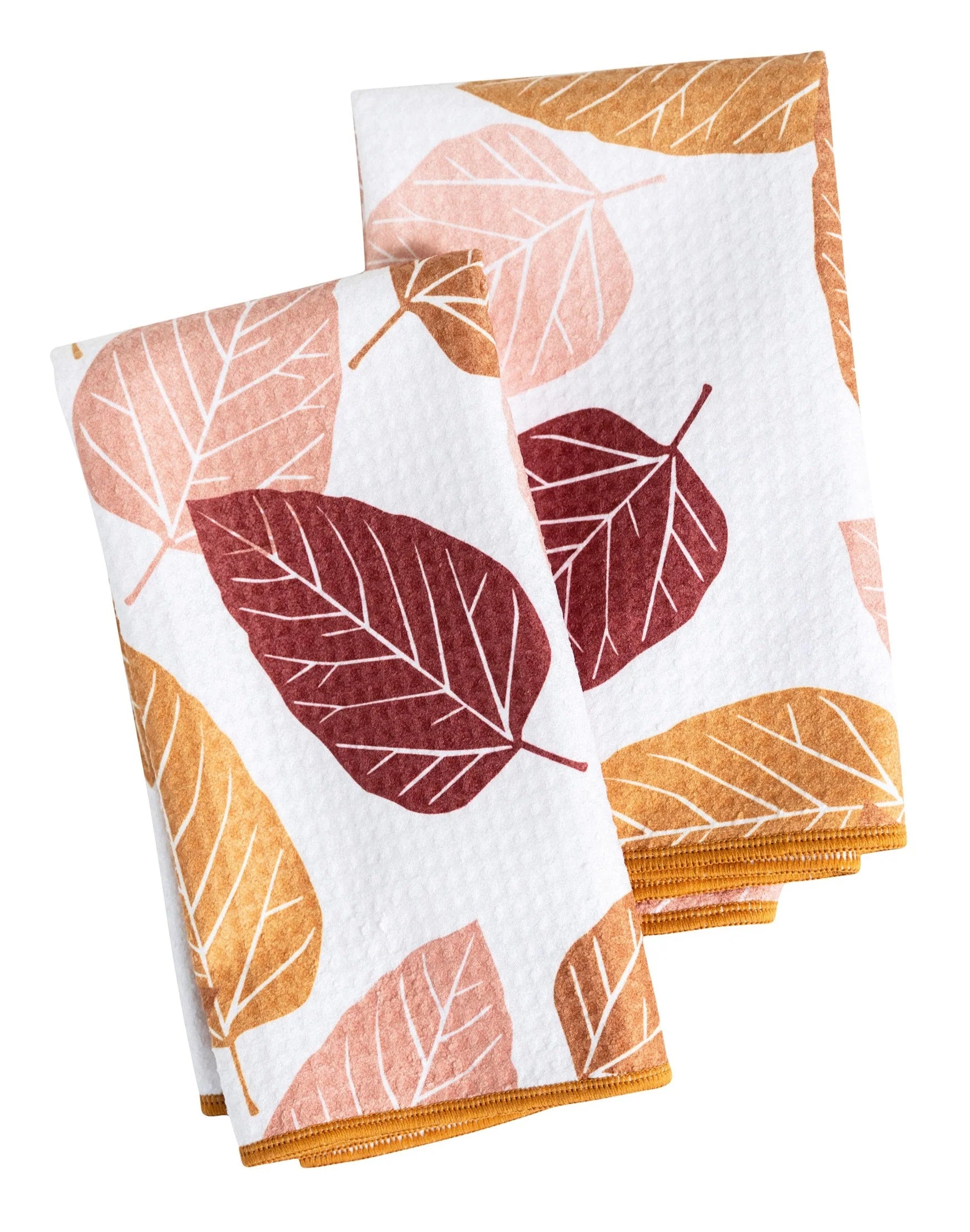folded white biggie towels printed with leaves in shades of yellow pink and maroon.