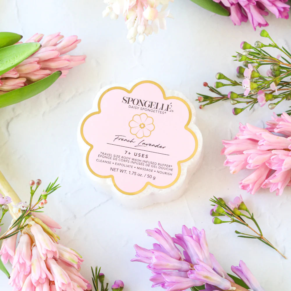 Spongellé product with pink flowers arranged around it on a white background