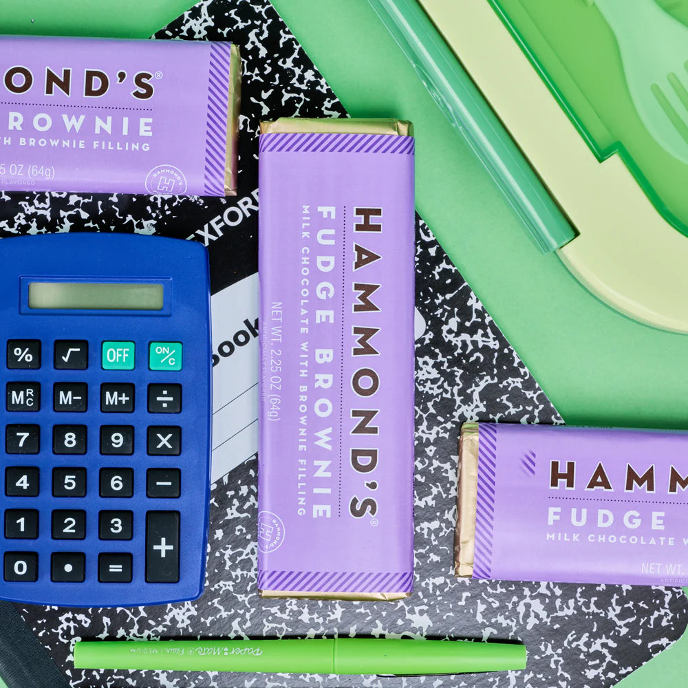 Fudge Brownie Milk Chocolate Candy Bars arranged on a desk with office supplies