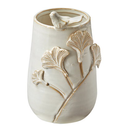 Ceramic vase with bird and leaf designs on a white background