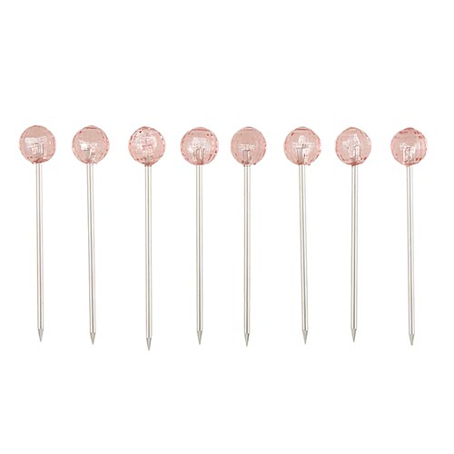 appetizer picks with pink crystal heads in a row on a white background.