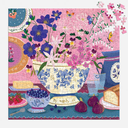 mostly finished puzzle with floral and teacup design with a few of its pieces from the top corner scattered about