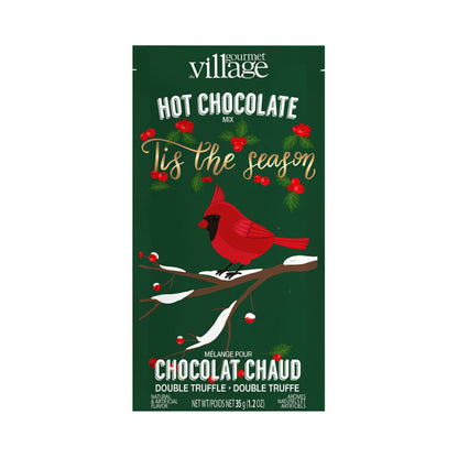 Gourmet Village hot chocolate mix packaging with a cardinal and holly design on a green background.