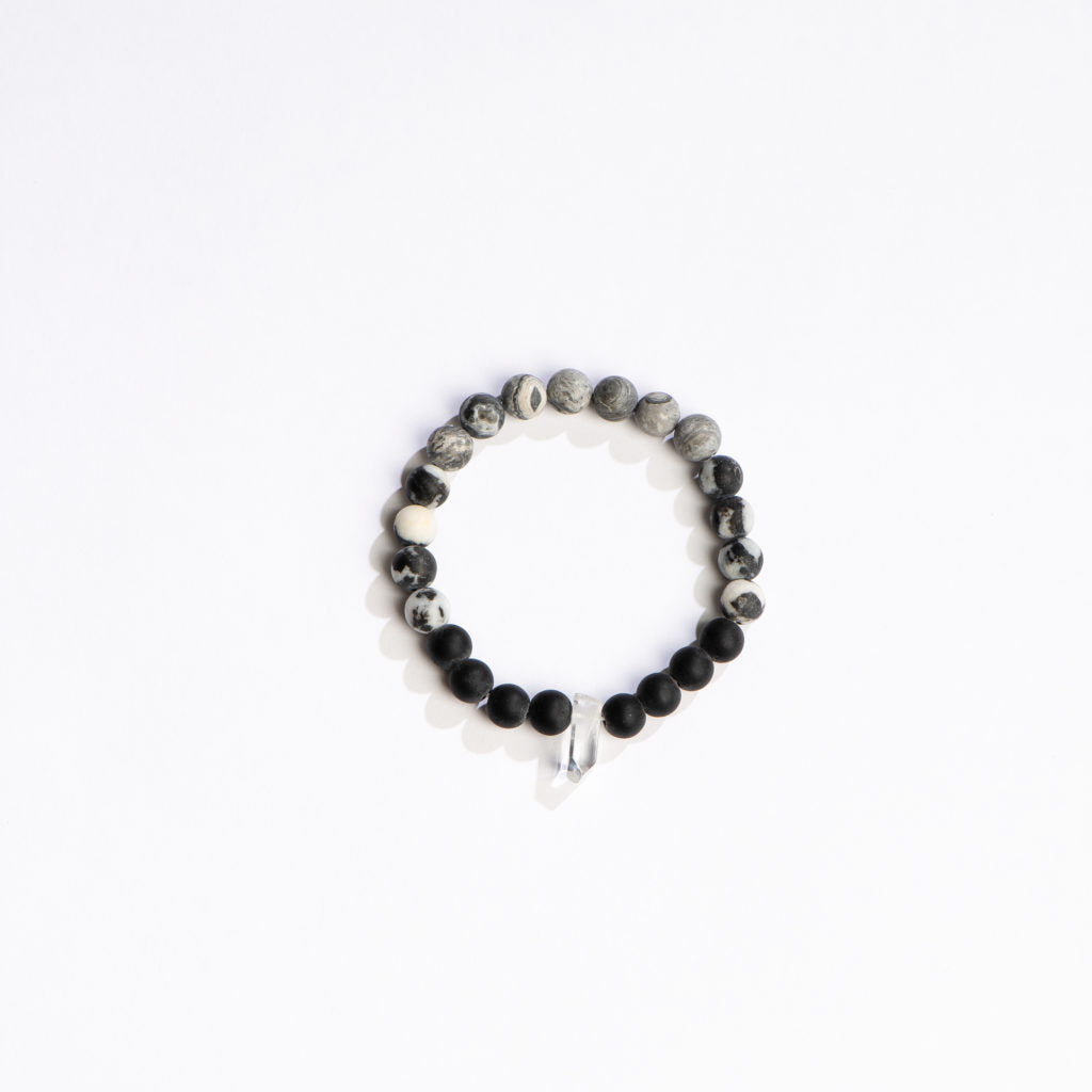 black and grey beaded bracelet with crystal on a white background.