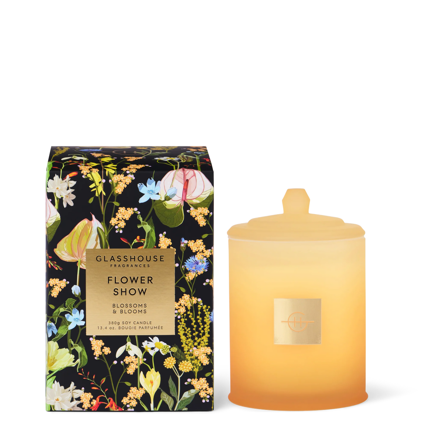 Glasshouse Flower Show candle in a pale yellow jar set next to its floral packaging on a white background