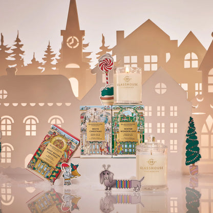 Candle collection with decorative packaging against a paper cityscape background 