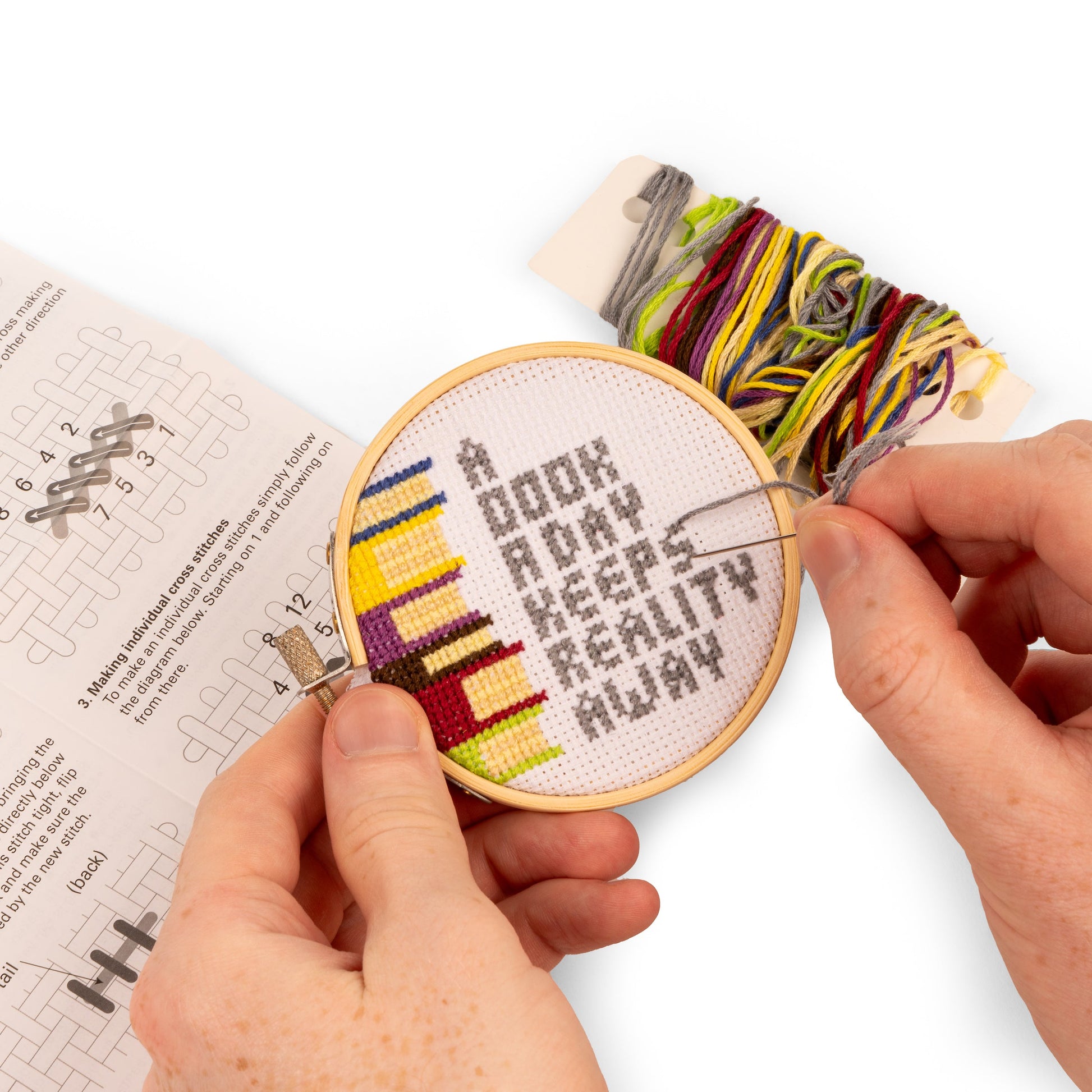 hands holding books embroidery kit