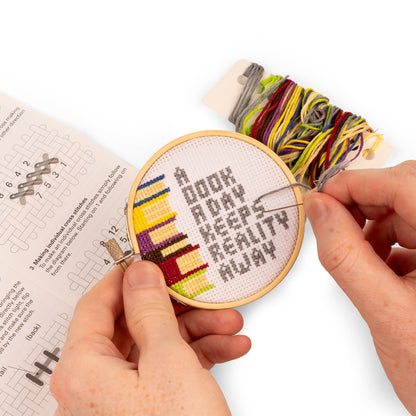 hands holding books embroidery kit