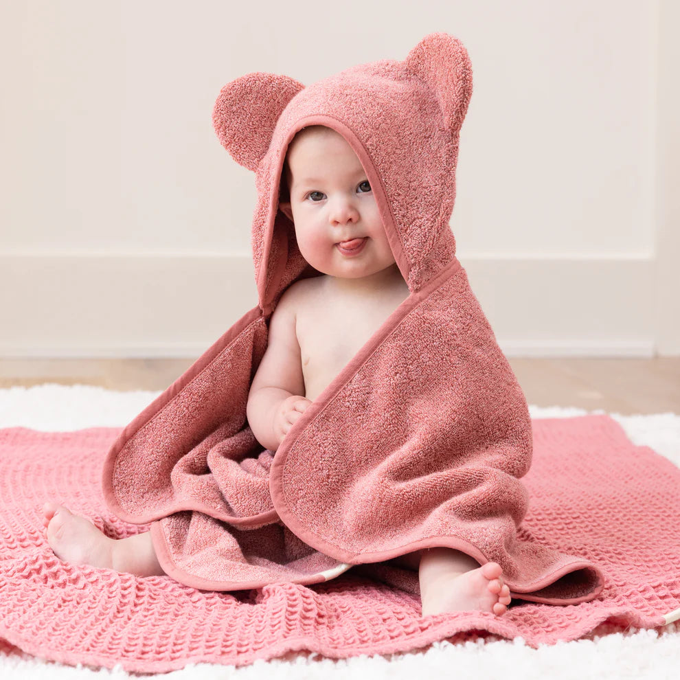 baby wrapped in watermelon towel with hood on.