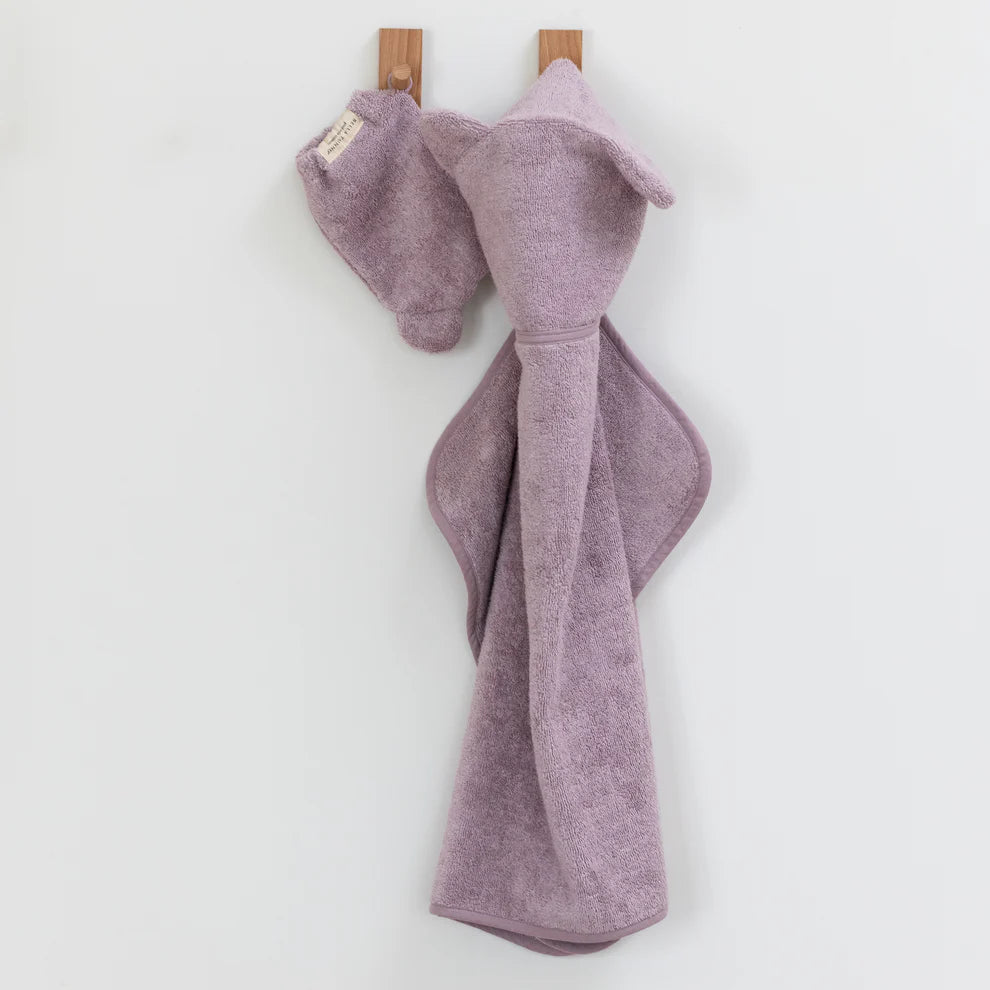 orchid towel and mitt set hanging on wooden pegs.