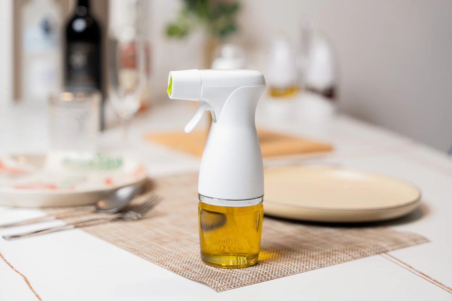 White spray bottle with oil on a kitchen counter