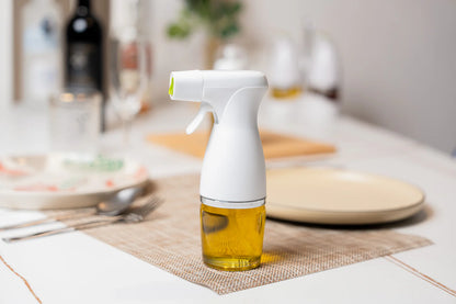 White spray bottle with oil on a kitchen counter