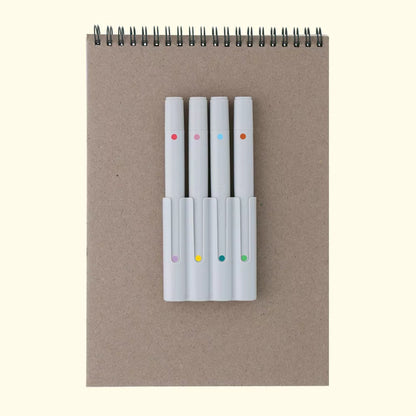 Set of markers with color dots on a notebook