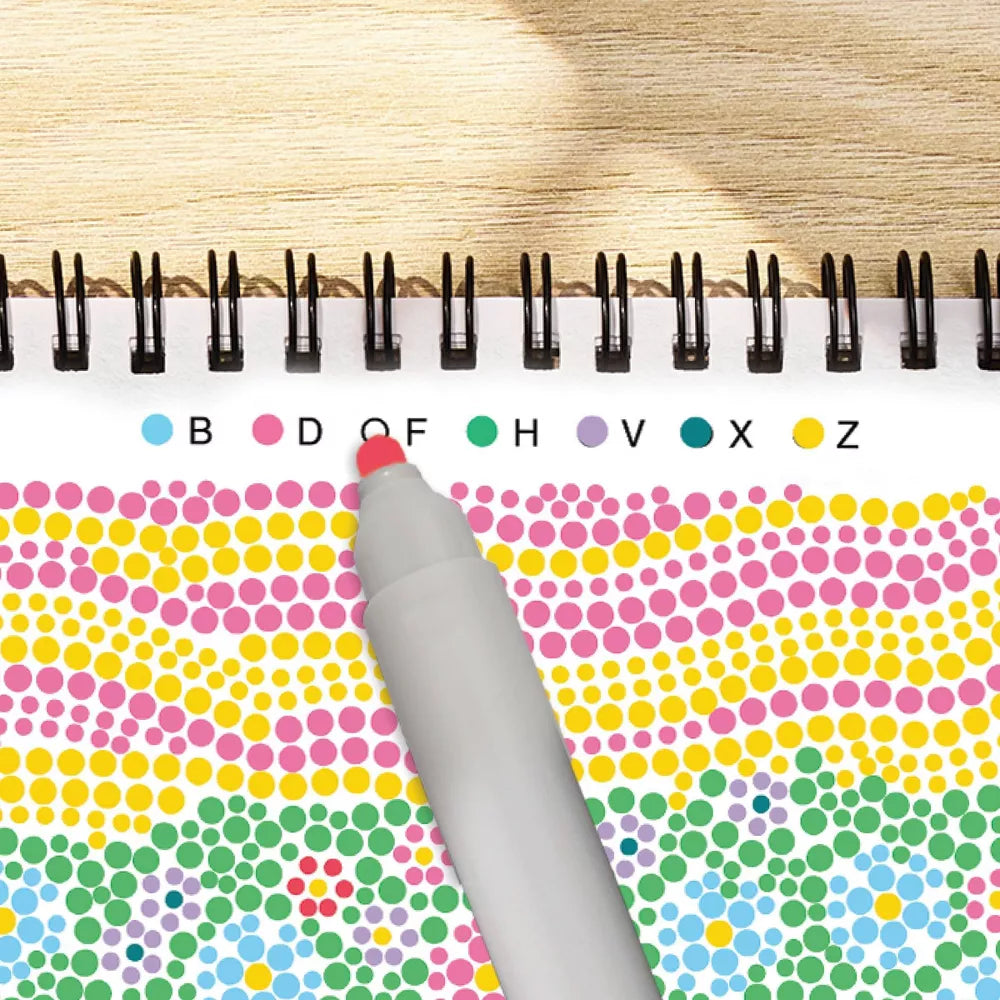 Color dot book with a pen on a wooden surface