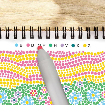 Color dot book with a pen on a wooden surface