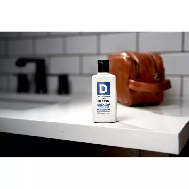 Body wash bottle on a bathroom counter with a blurred background