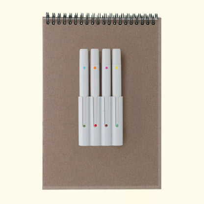 Notebook with a set of white markers on a beige background