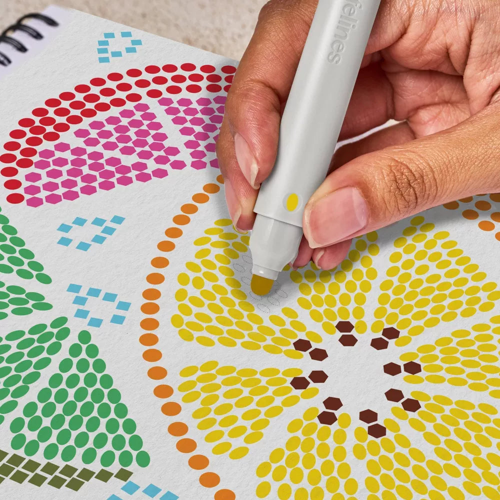 Hand holding a dot marker over a colorful dot pattern on paper