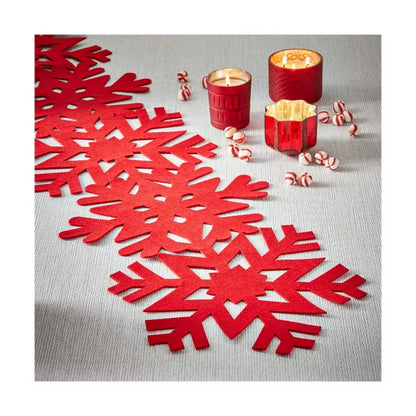 Red felt snowflake runner laying on a table with candles and candy.