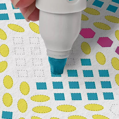 White marker with blue ink being used on a patterned background