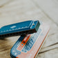 close-up of harmonica and tin case on a wooden background.
