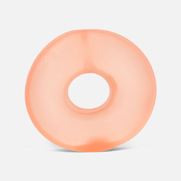 Peach-colored donut-shaped stress ball on a light gray background