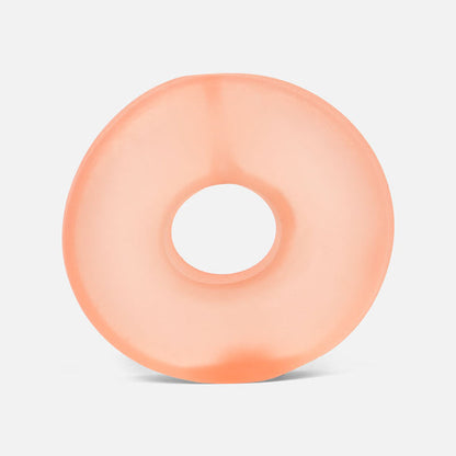 Peach-colored donut-shaped stress ball on a light gray background