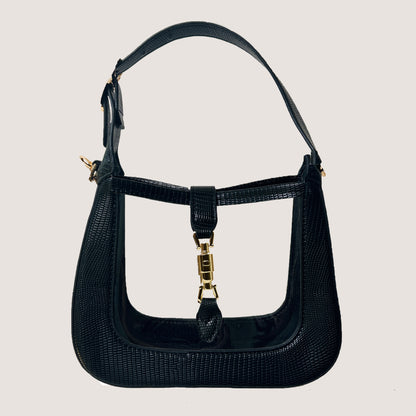 The Paige Clear Stadium Bag in Black on a taupe background
