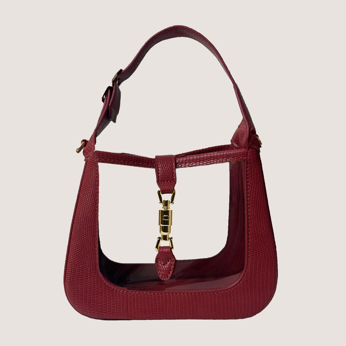The Paige Clear Stadium Bag in Red on a taupe background