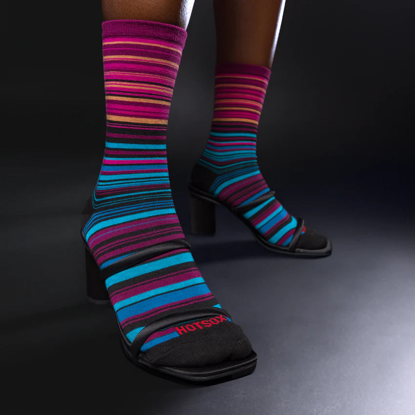 feet wearing black, purple, blue, and pink striped socks and black heals.
