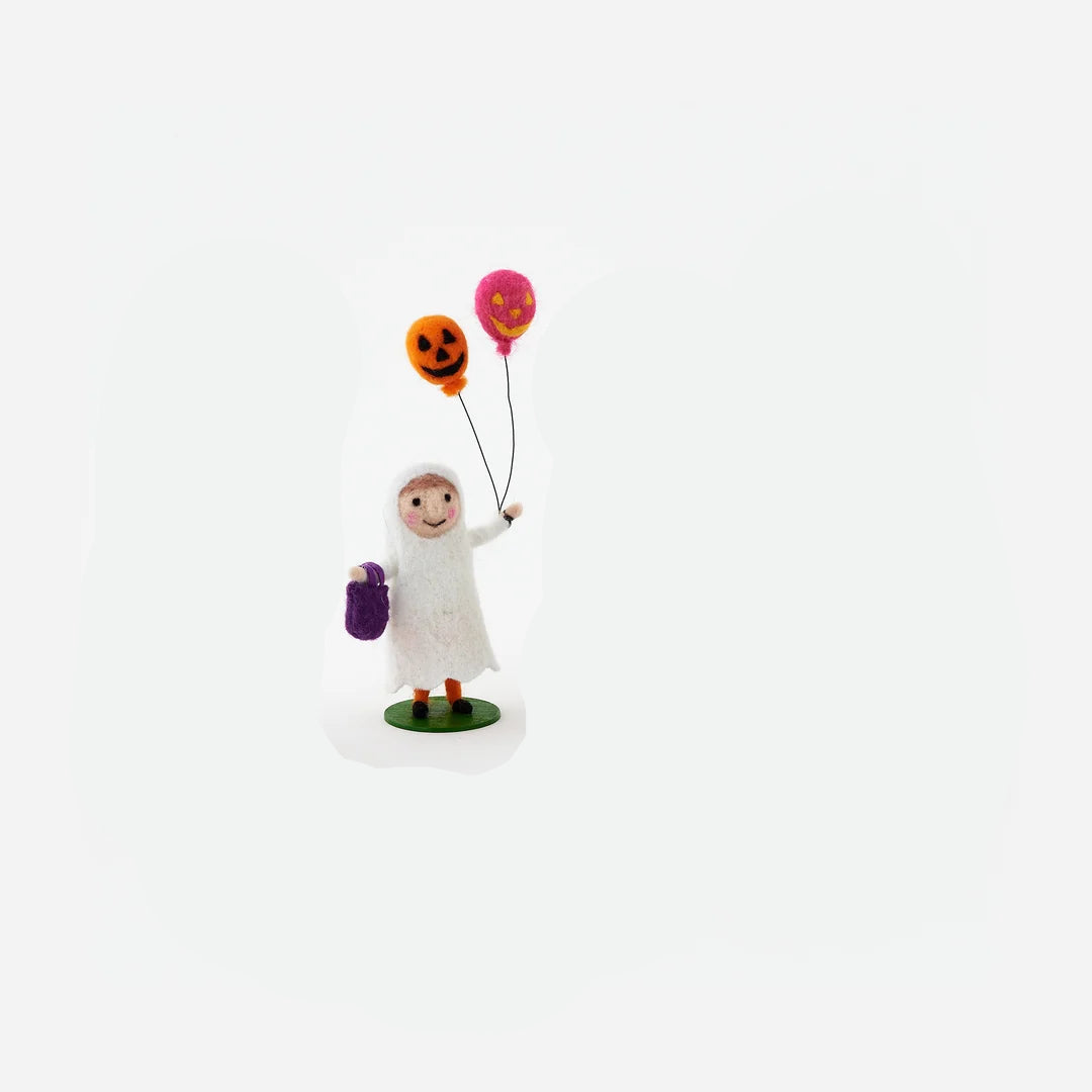 small felt figurine a child dressed in ghost costume holding orange and pink balloons